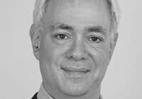 Portrait of a smiling man in grayscale.