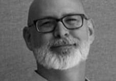 Smiling bald man with beard and glasses