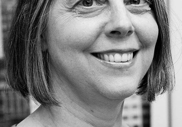 Smiling woman with short hair, black-and-white portrait.