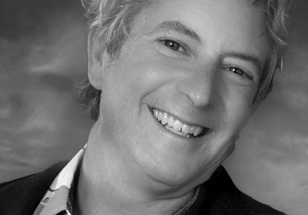 Smiling person in a black and white portrait.